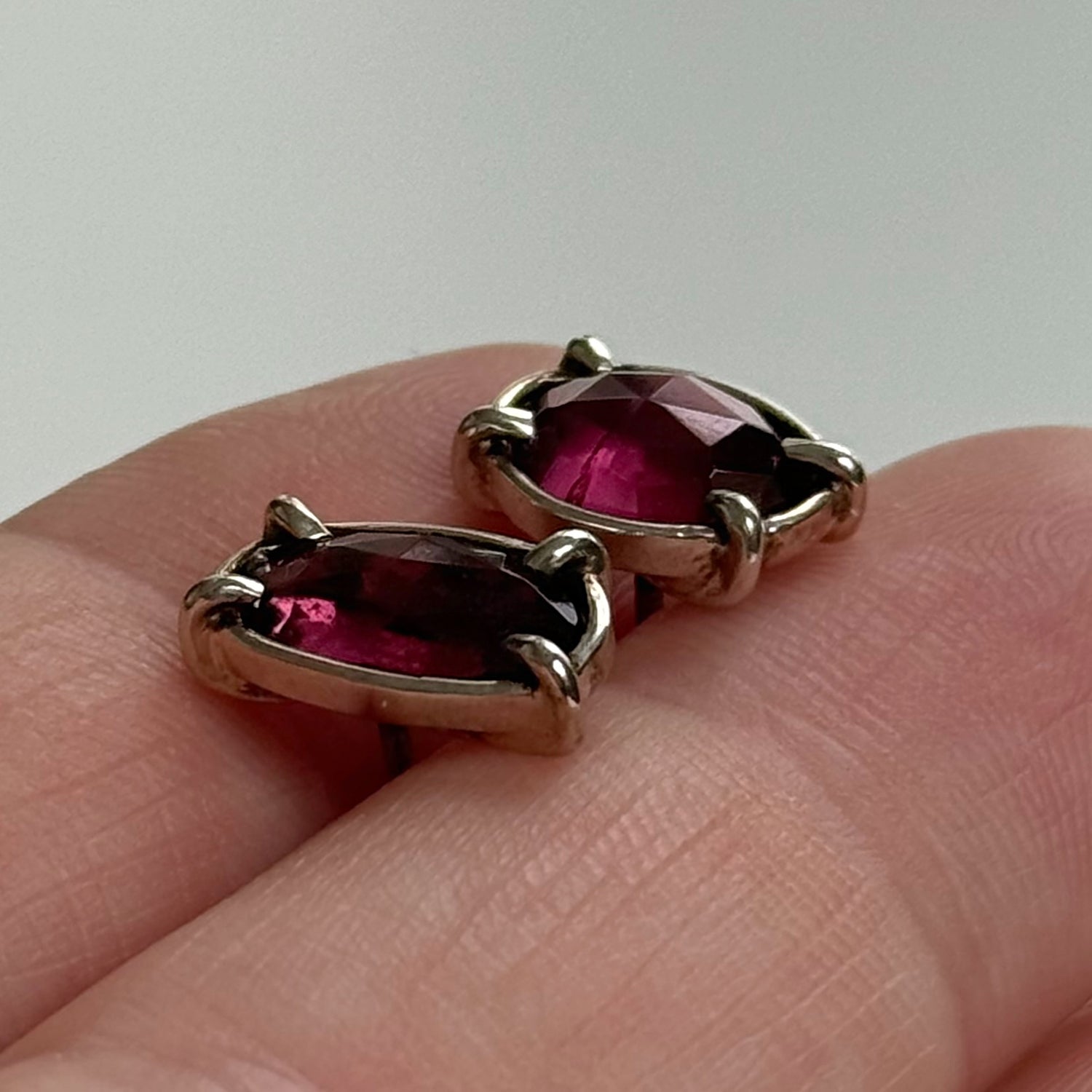 Elegant Rhodolite garnet earrings set in a silver design, showcasing their rich red color