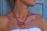 Mosaic double face jewelry pendant showcased on a model with a red cord necklace