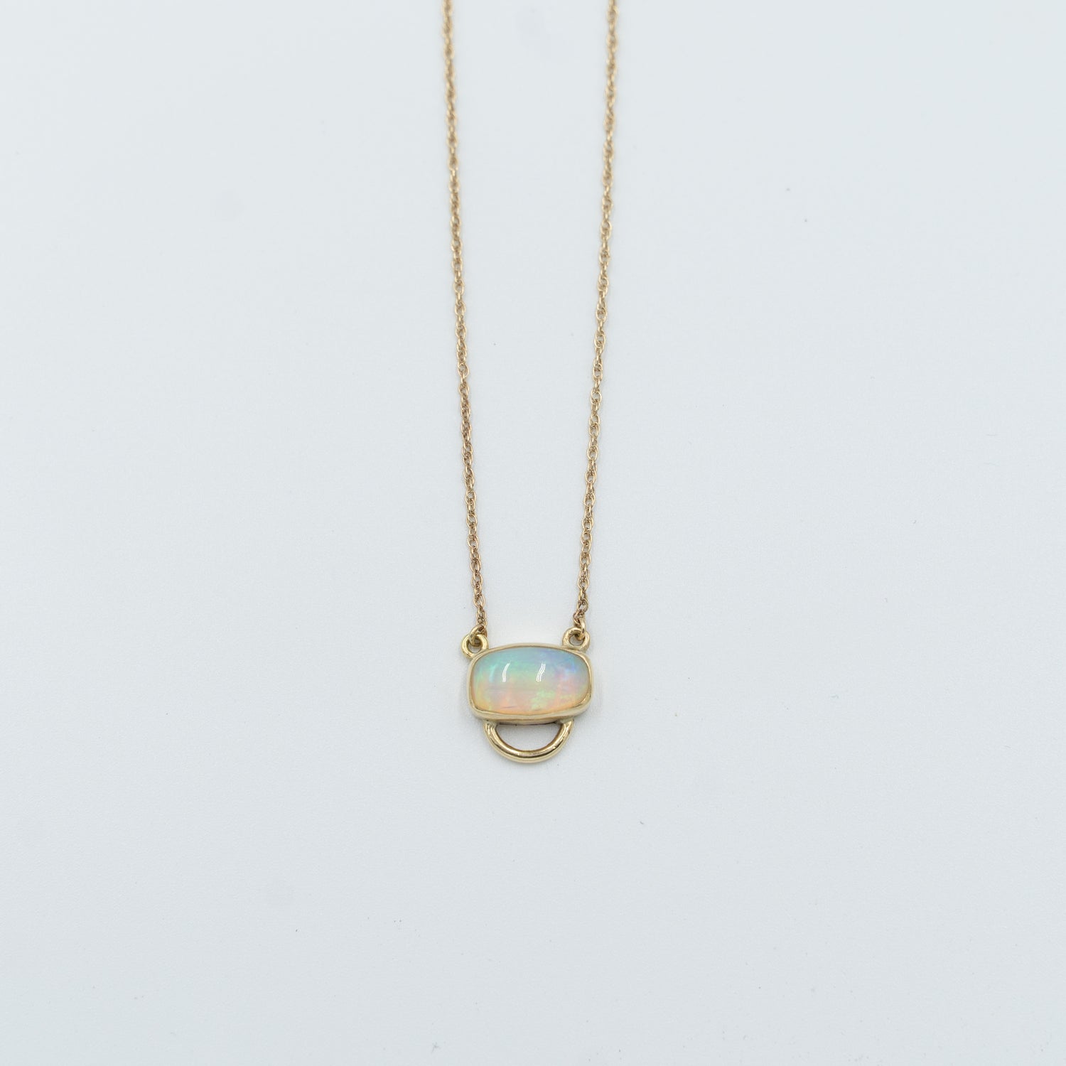 Unique opal pendant necklace with a delicate gold chain and oval opal stone from Tess Young Jewelry at The W Gallery