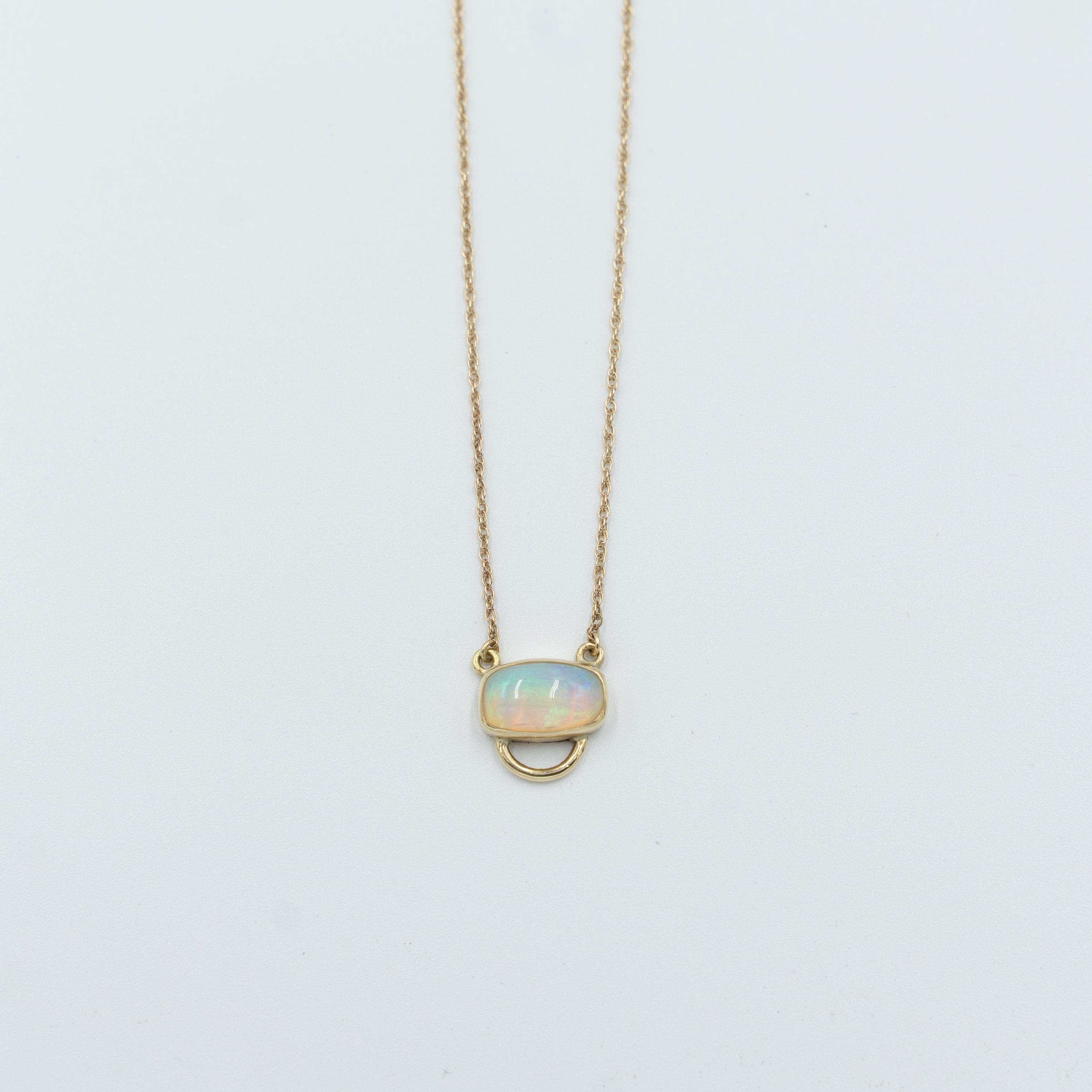 Unique opal pendant necklace with a delicate gold chain and oval opal stone from Tess Young Jewelry at The W Gallery