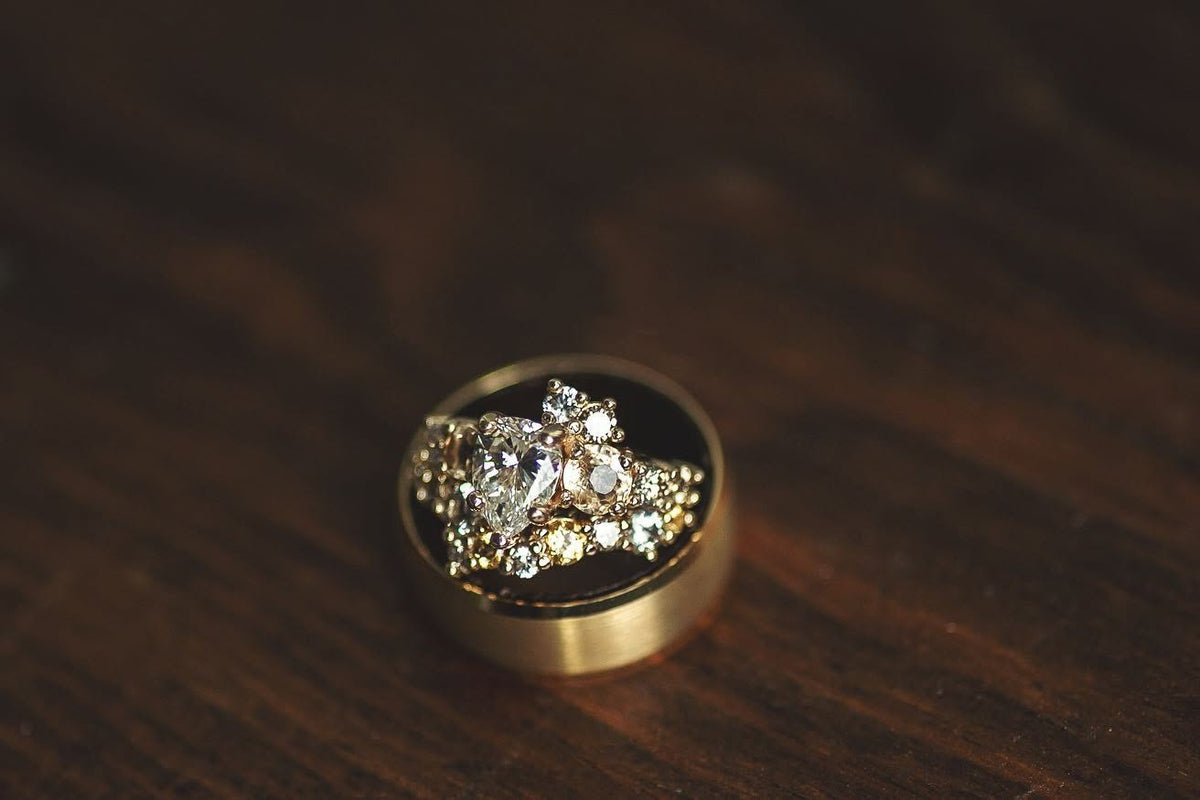 A custom wedding ring for her nestled inside of a custom gold wedding band for him