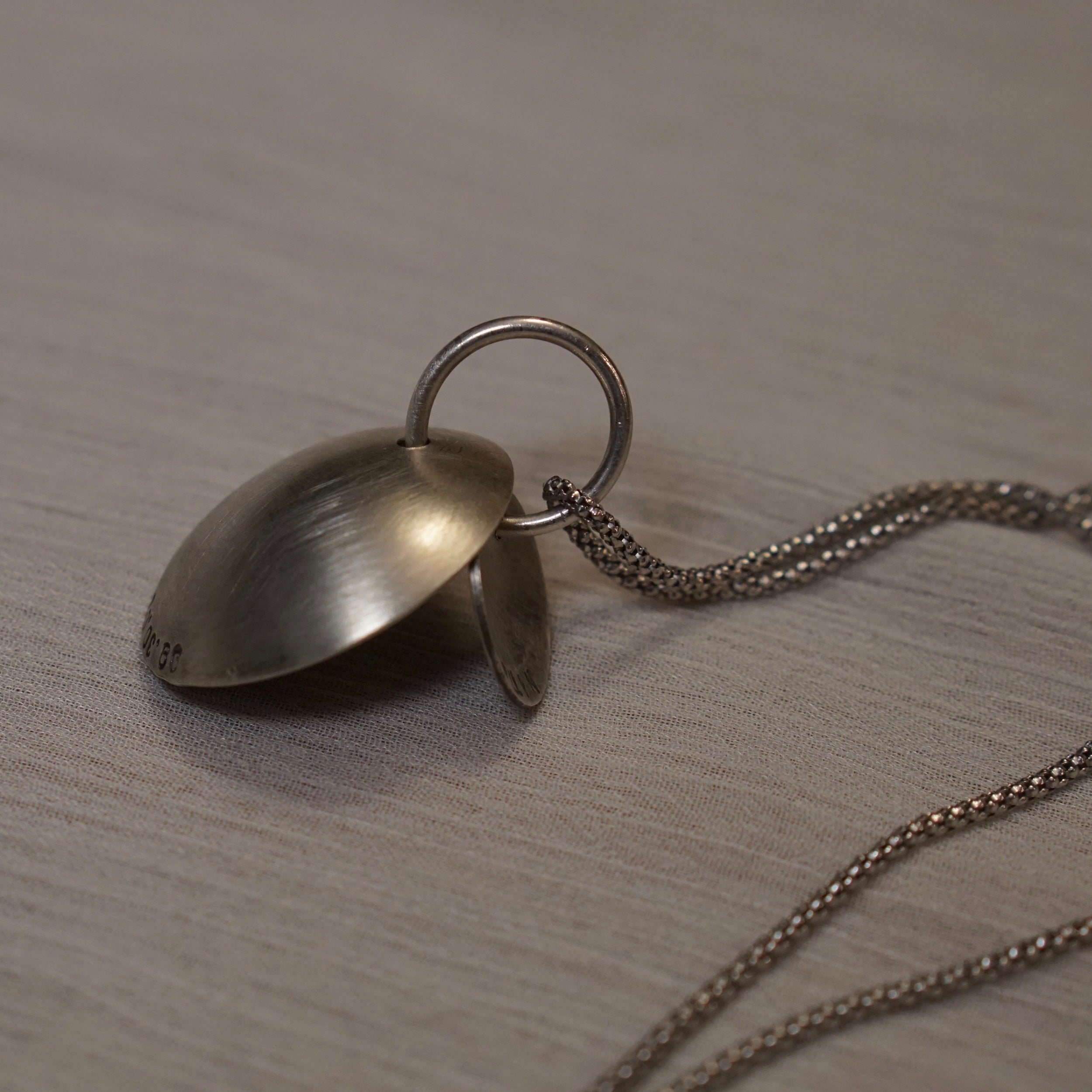 A nesting disc necklace that can be personalized with dates and names of family members or pets